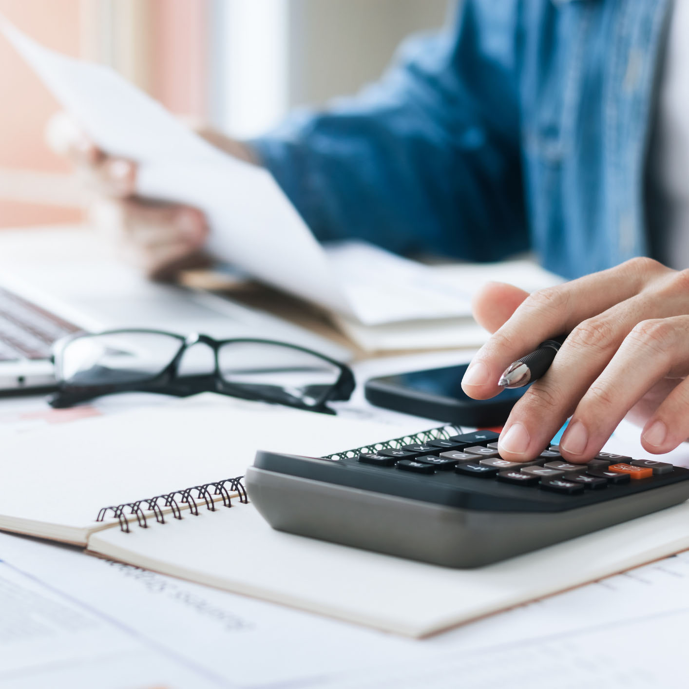 man doing bills with paper and calculator