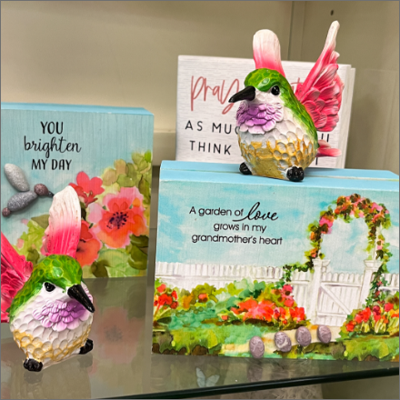 colorful bird decorations on glass shelf